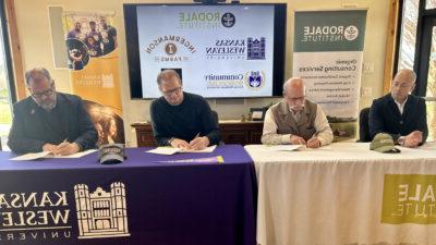 Men at tables signing documents